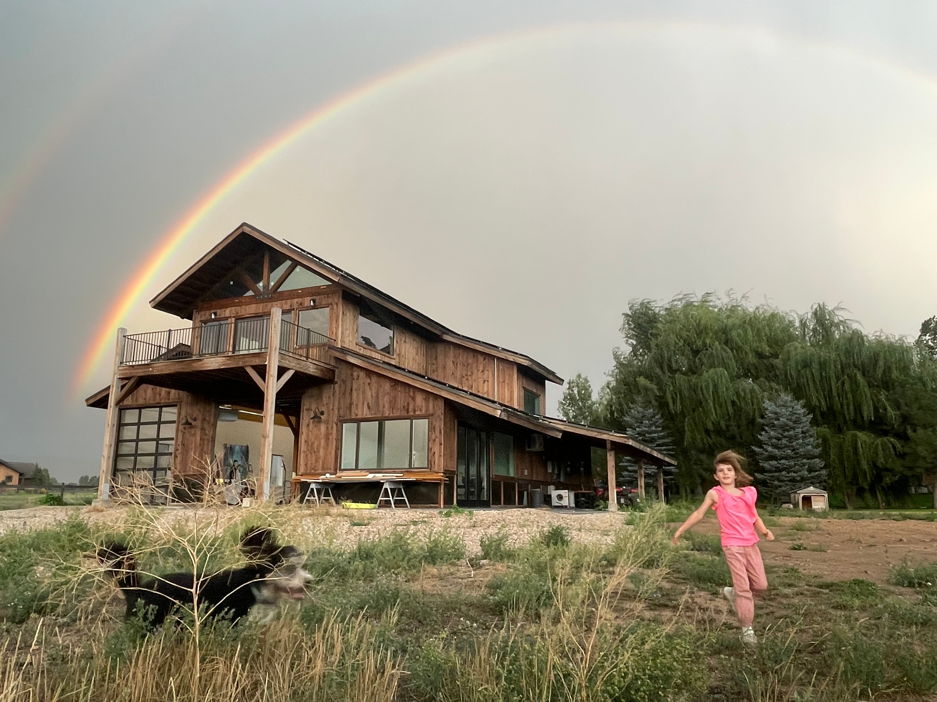 Rainbow arching over the barn after a summer storm